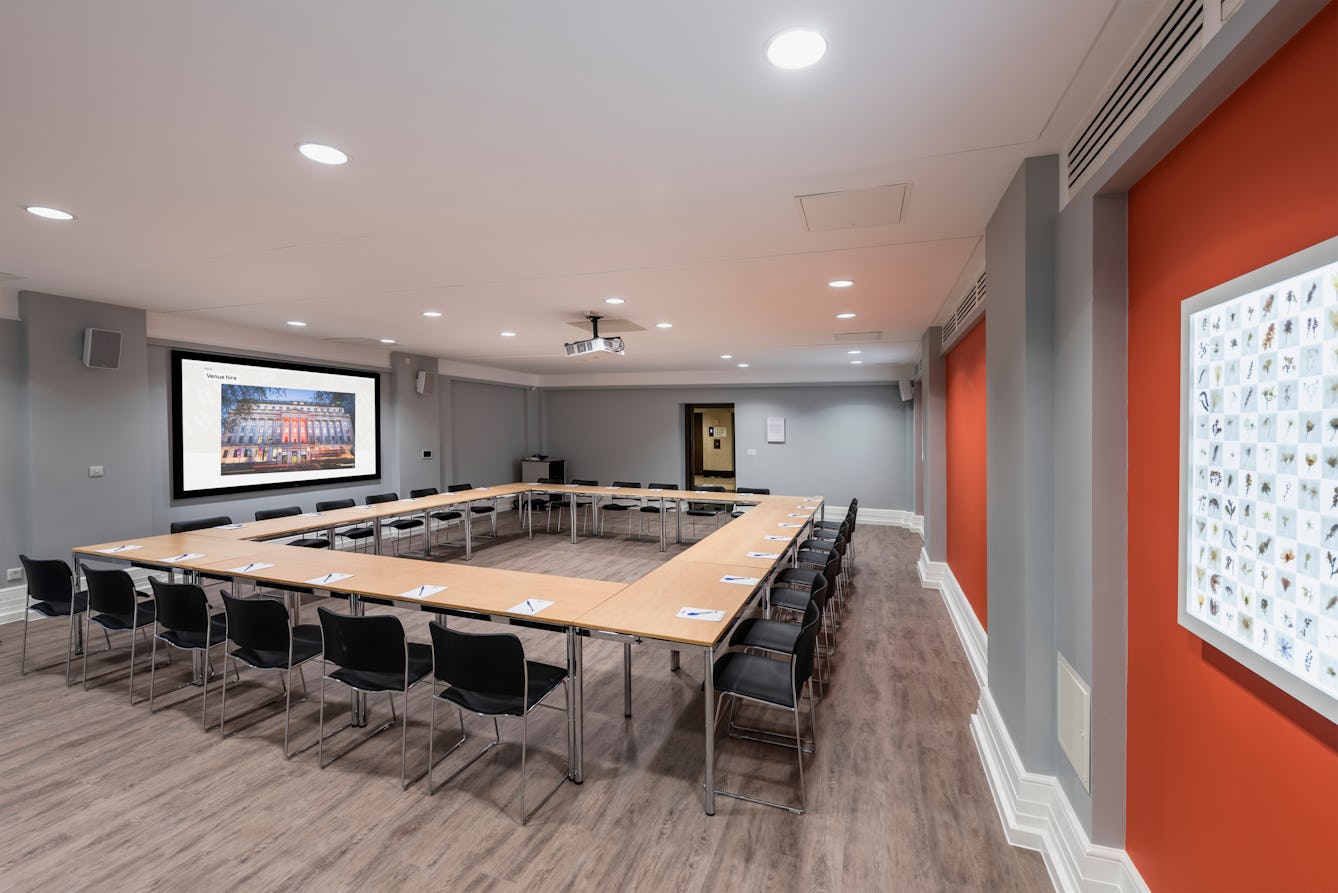 Photograph of the Burroughs room at the Wellcome Collection.
Photograph shows a boardroom set-up and a presenting screen at the front of the room.