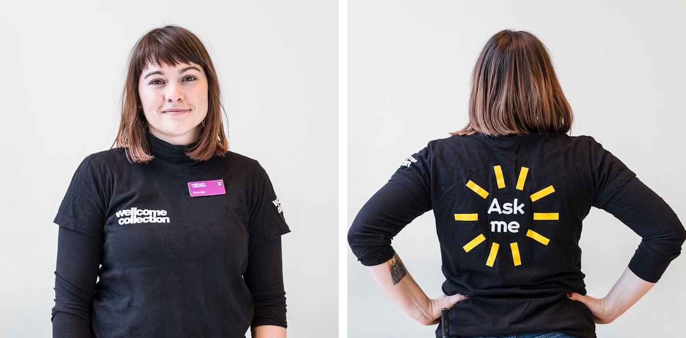 Diptych. The photograph to the left shows a smiley visitor experience assistant wearing a black t-shirt with a white Wellcome Collection logo and a pink name badge. The photograph to the right features the same visitor experience assistant seen from the back. On the reverse of the t-shirt it says 'Ask me' in large white letters with straight yellow lines radiating outwards in a circle like a child's drawing of a sun.
