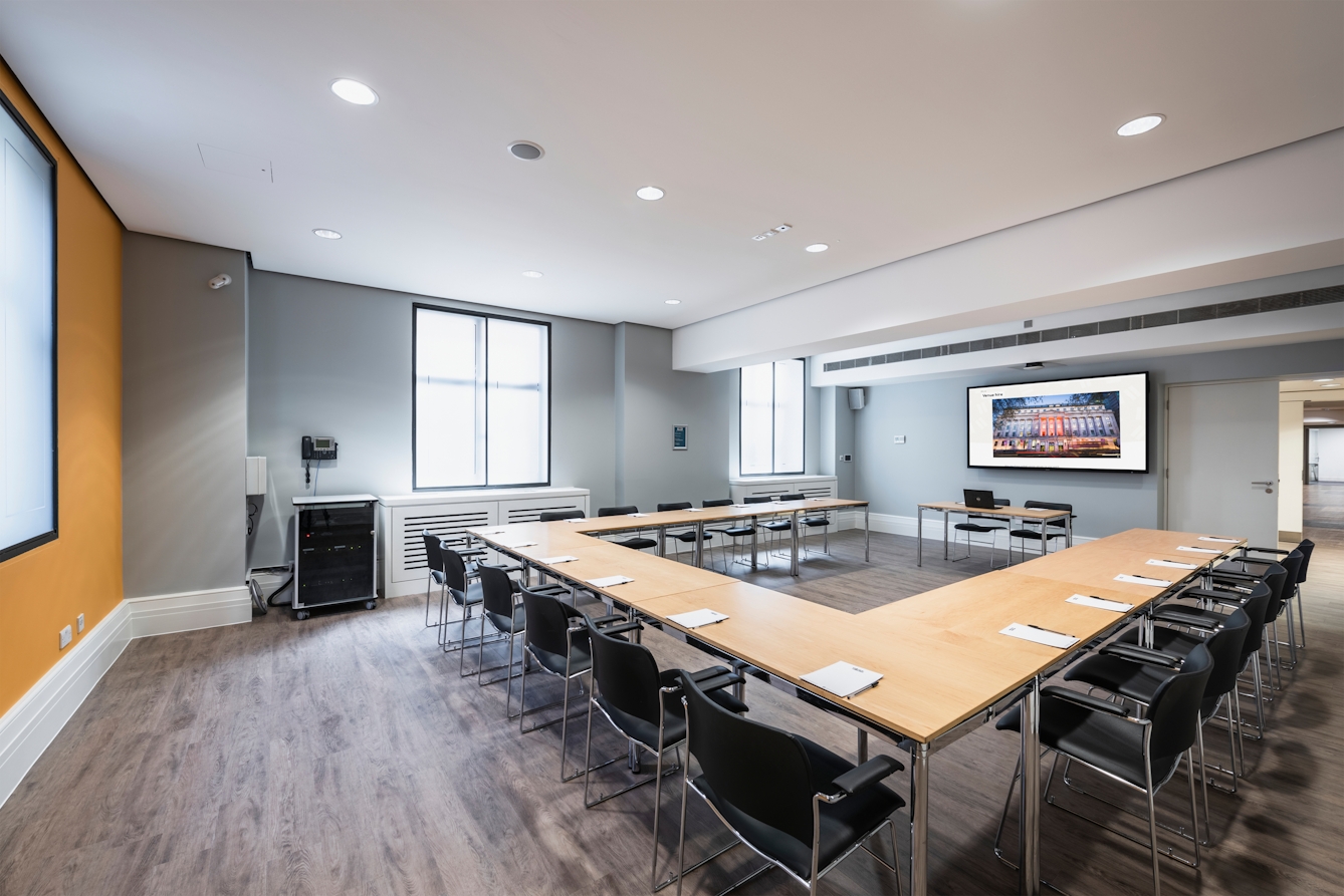 Photograph of the Dale room at the Wellcome Collection.
Photograph shows a U-shape desk set-up and a presenting screen at the front of the room.