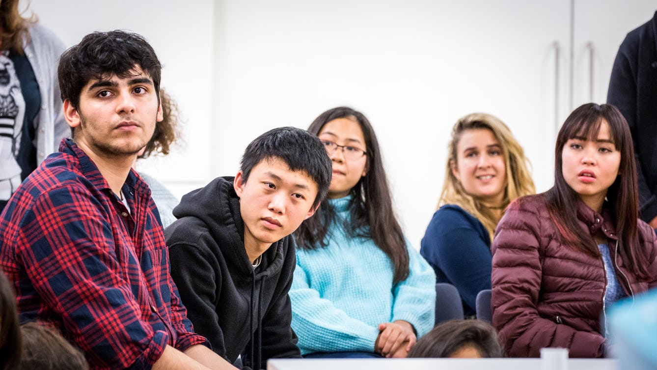 Photograph of a group of young people listening to a presenter who is stood 'off camera'.