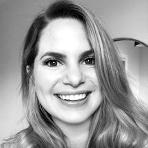 Black and white photograph of a young, white woman with long fair hair looking directly at the camera and smiling.