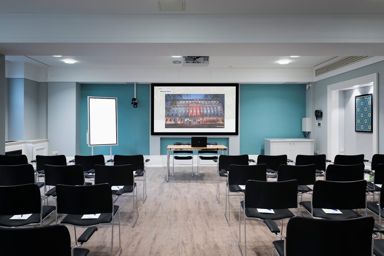 Photograph of the Franks room at the Wellcome Collection.
Photograph shows a theatre space with chair, a whiteboard and a projector and screen set-up.