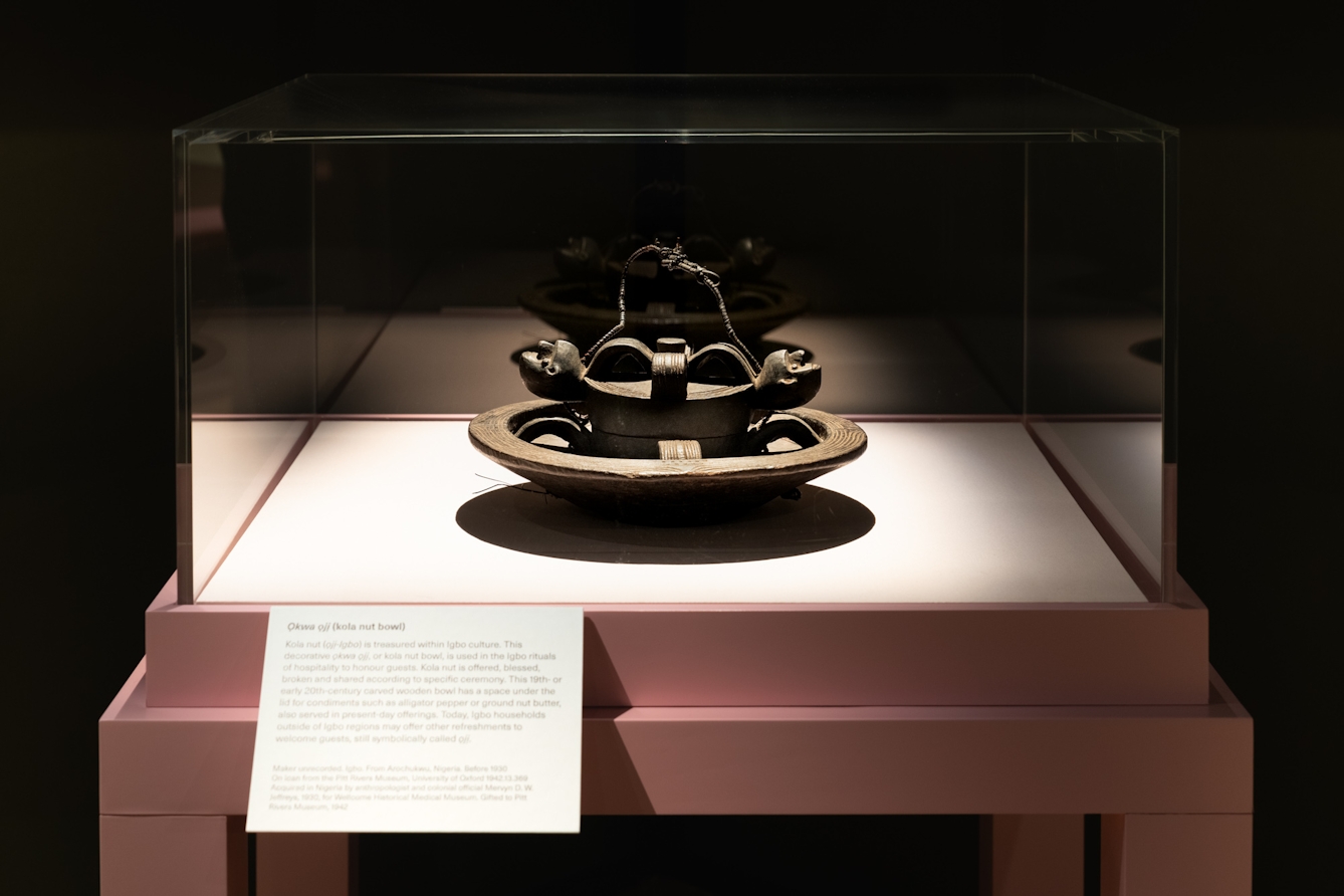 Photograph of a carved wooden bowl in a display case.
